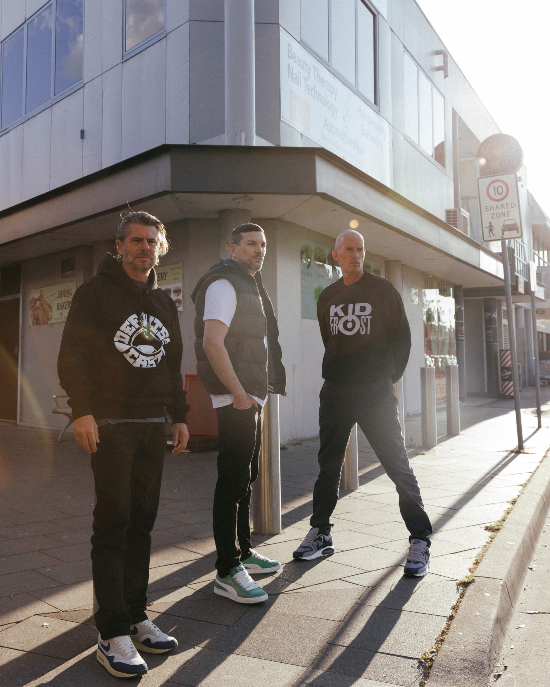 Three men standing on a street