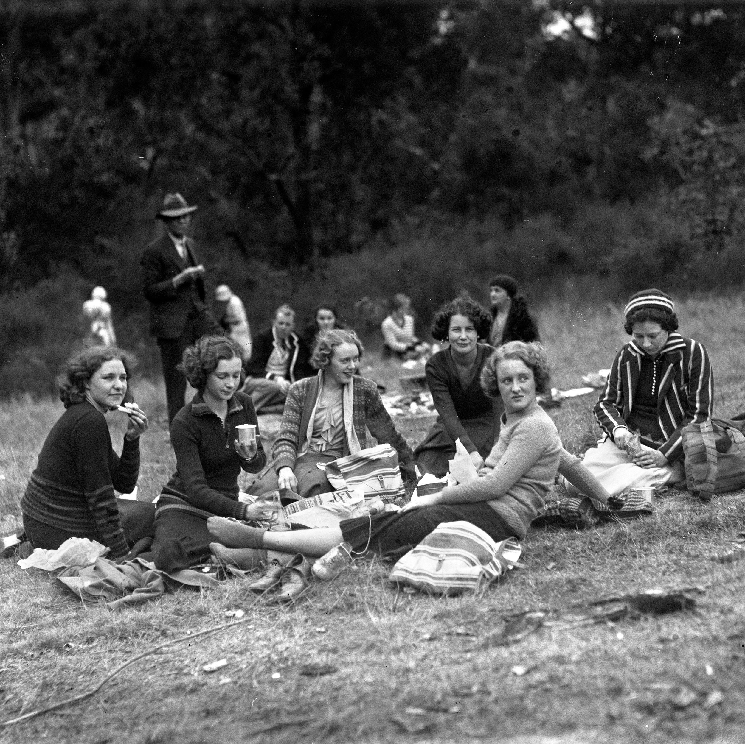 1930's women sitting on the grass, relaxing.