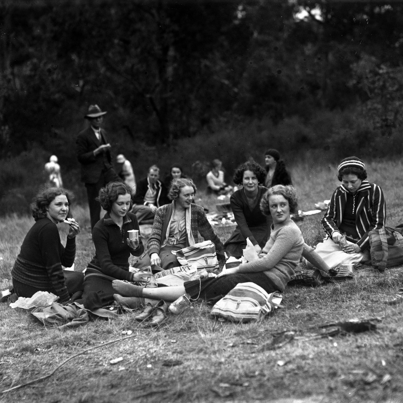 1930's women sitting on the grass, relaxing.