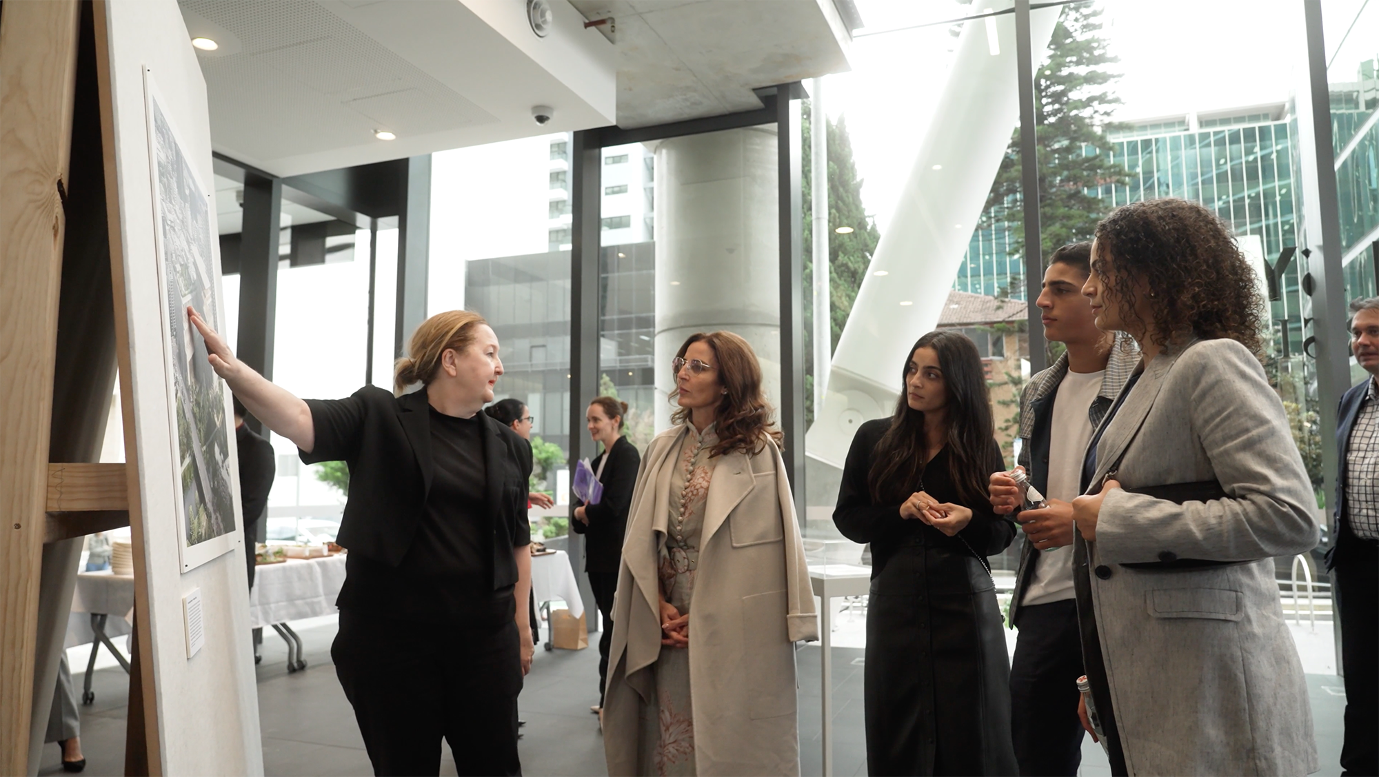 A group of people look at an artist impression of Powerhouse Parramatta, one person is pointing at the impression.