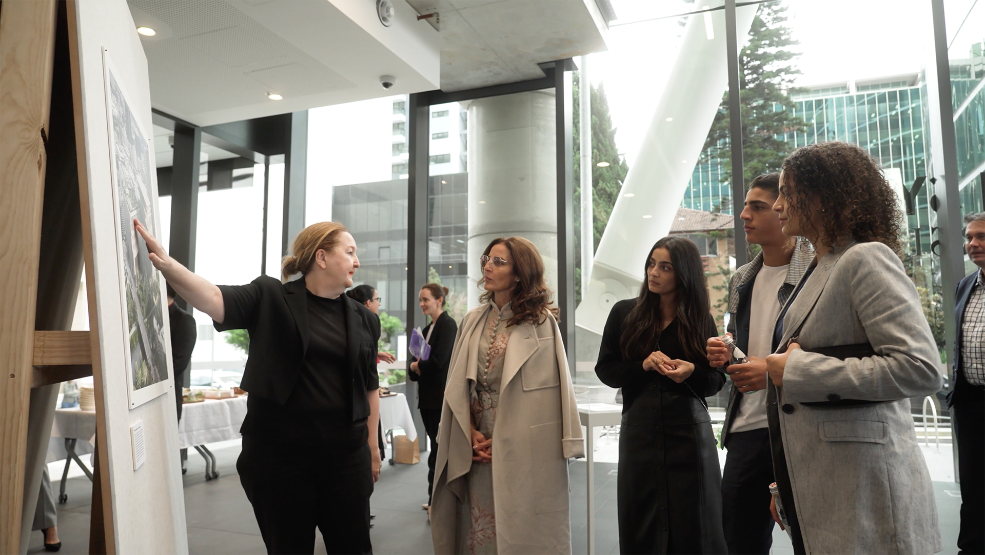 A group of people look at an artist impression of Powerhouse Parramatta, one person is pointing at the impression.