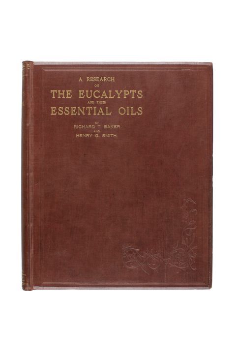 A book with a dark brown leather cover with title text ‘A Research on the Eucalypts and their Essential Oils’ embossed in gold.