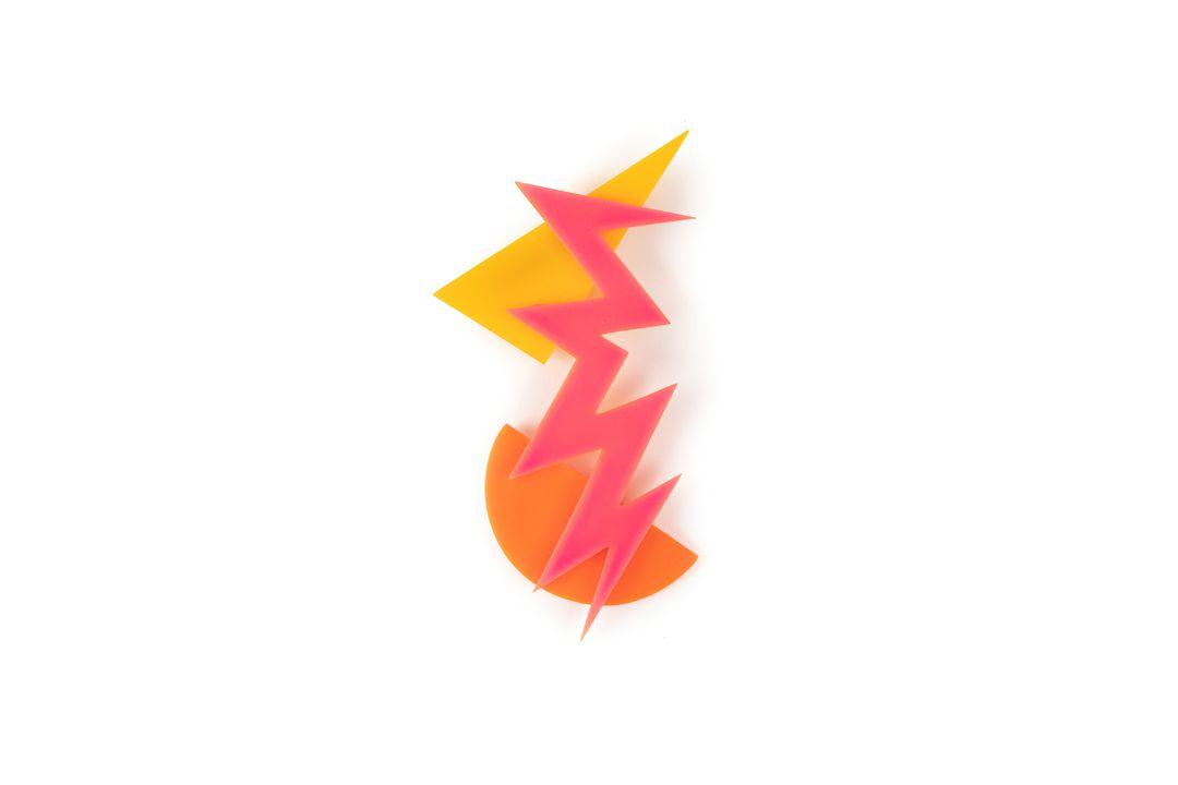 Three forms in flat acrylic sheet: a pink zig-zag over a yellow triangle and an orange hemisphere