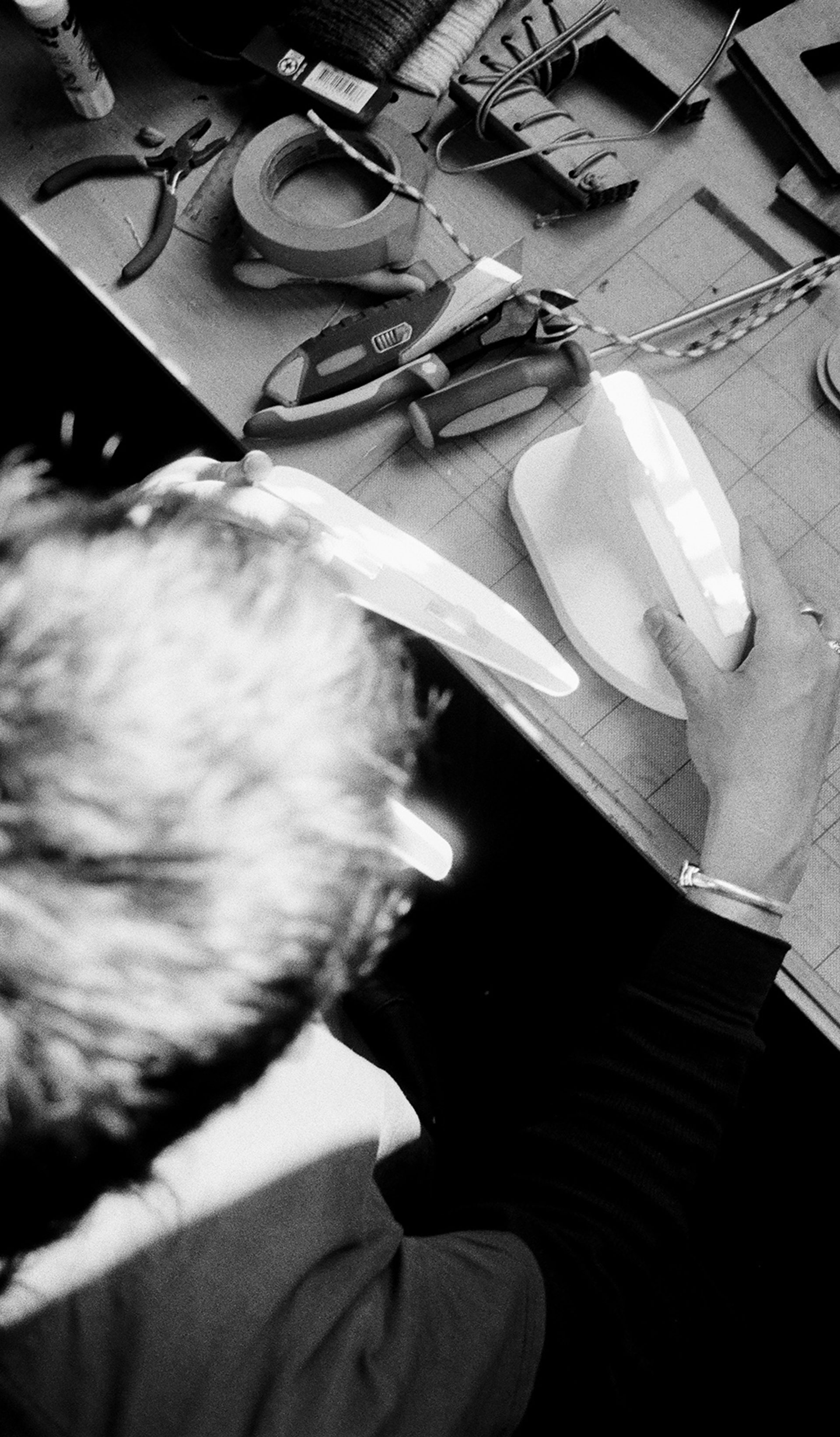 Two film images side by side – an overhead view of Ben Styles working on a product at a desk.