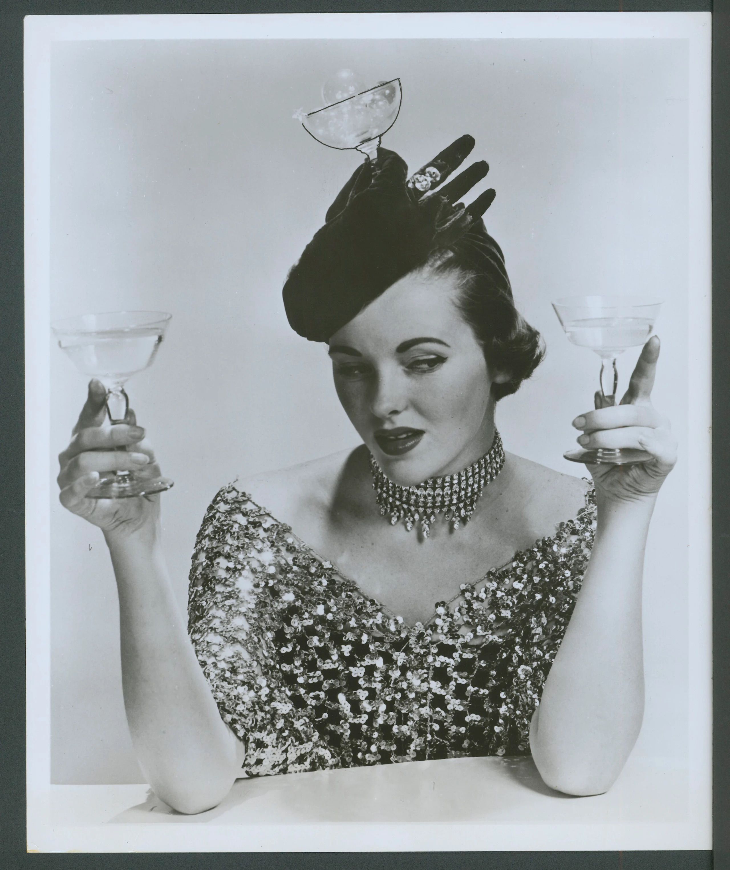A model wearing a hat, called 'Happy New Year 1953', which is decorated with a glove and champagne glass.