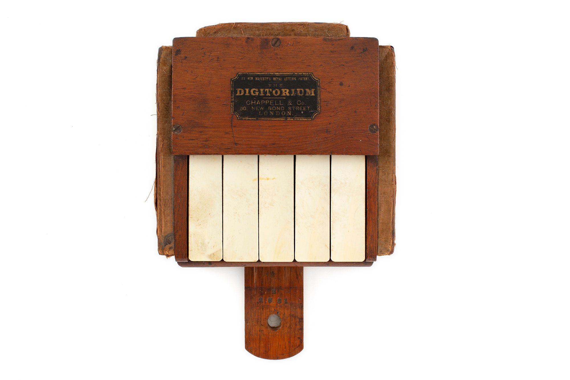 Square wooden box featuring five ivory piano keys. The device has a small timber slide at the front with a central hole.