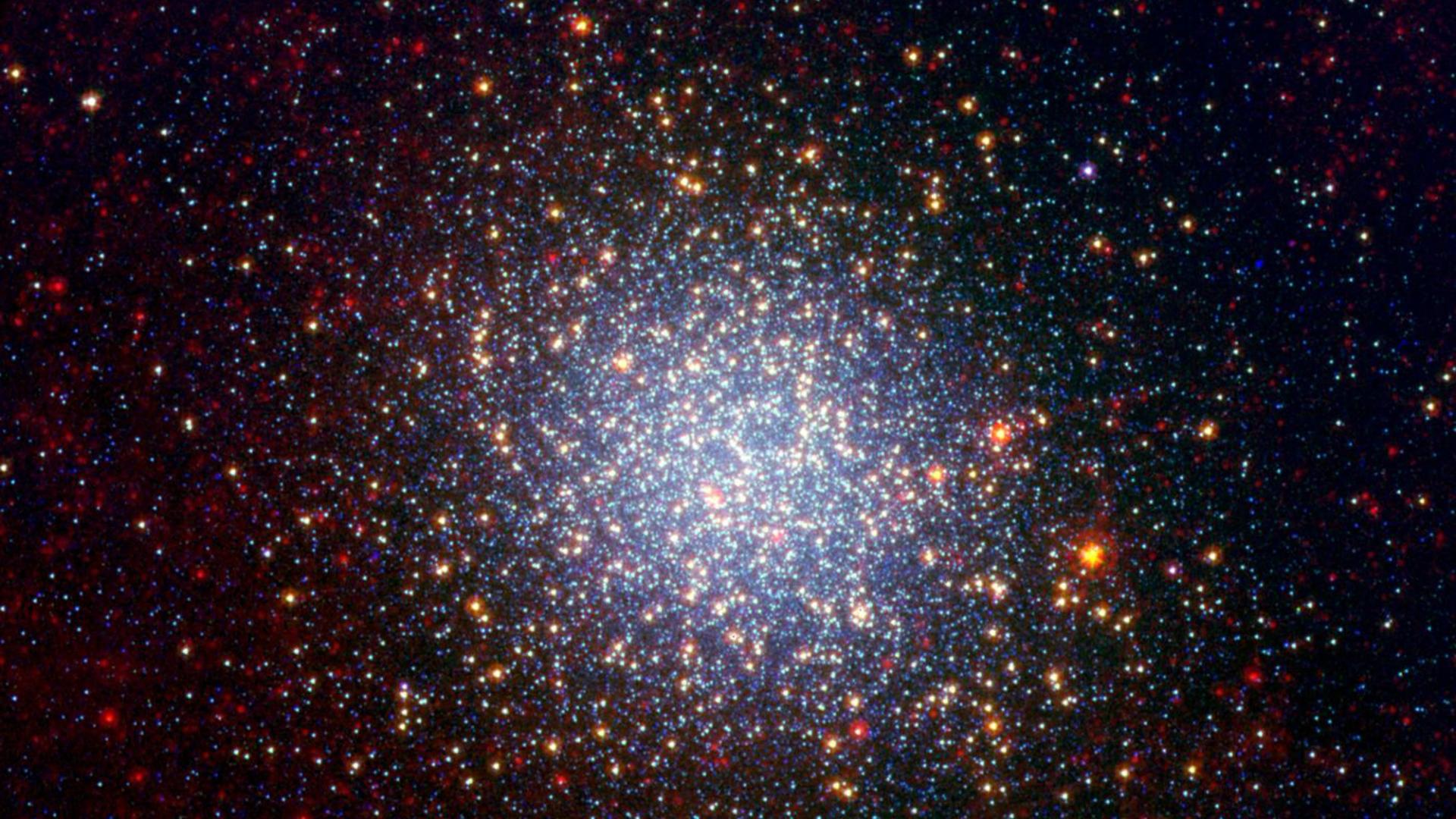 A cluster brimming with millions of stars glistens like an iridescent opal in this image from NASA Spitzer Space Telescope.