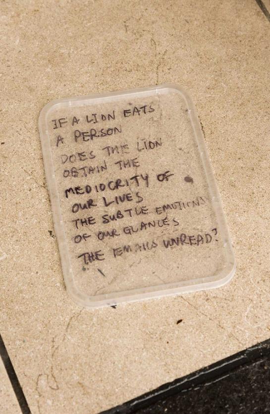 Note reading “IF A LION EATS A PERSON DOES THE LION OBTAIN THE MEDIOCRITY OF OUR LIVES THE SUBTLE EMOTIONS OF OUR GLANCES THE EMAILS UNREAD”