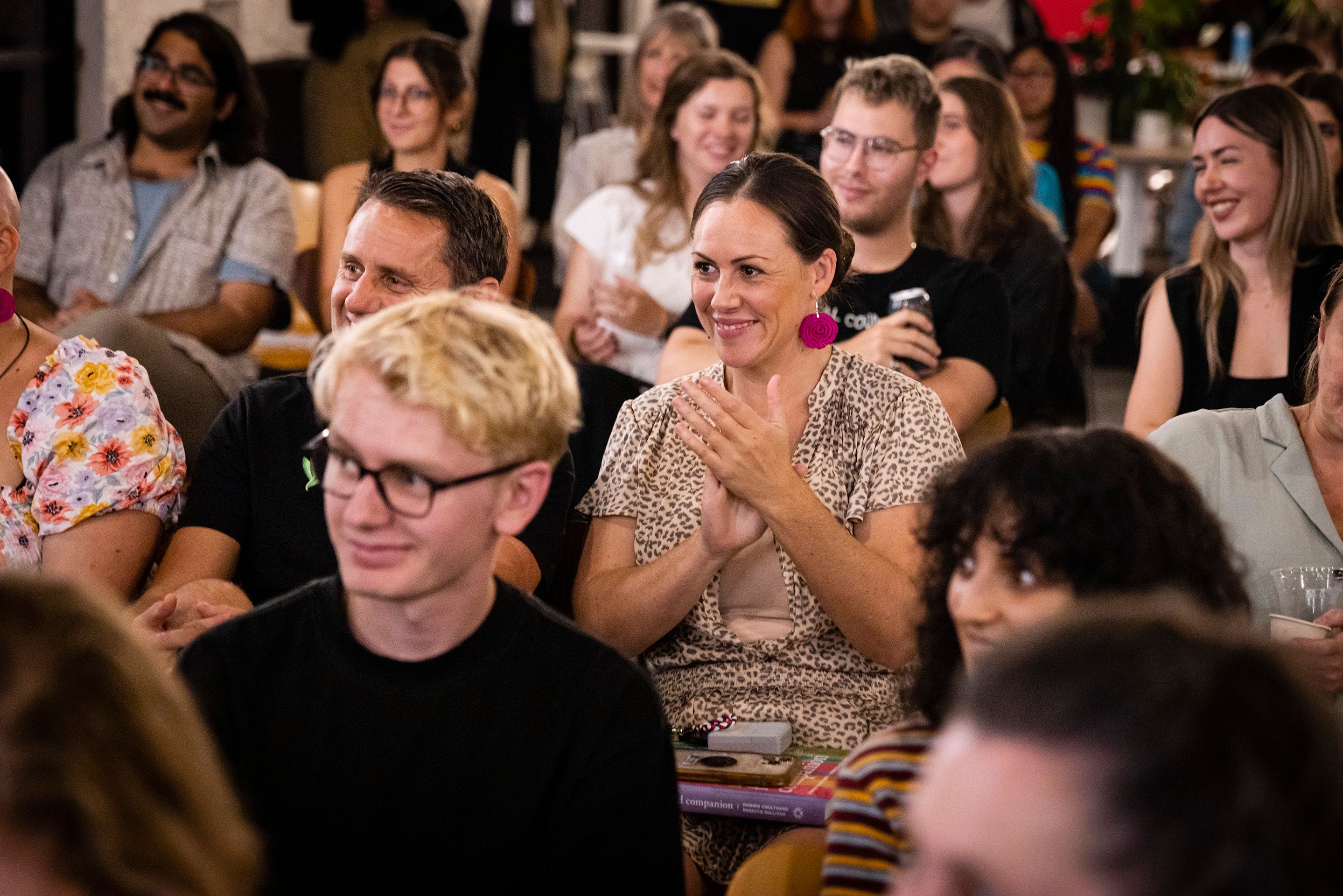 People sitting, smiling and clapping