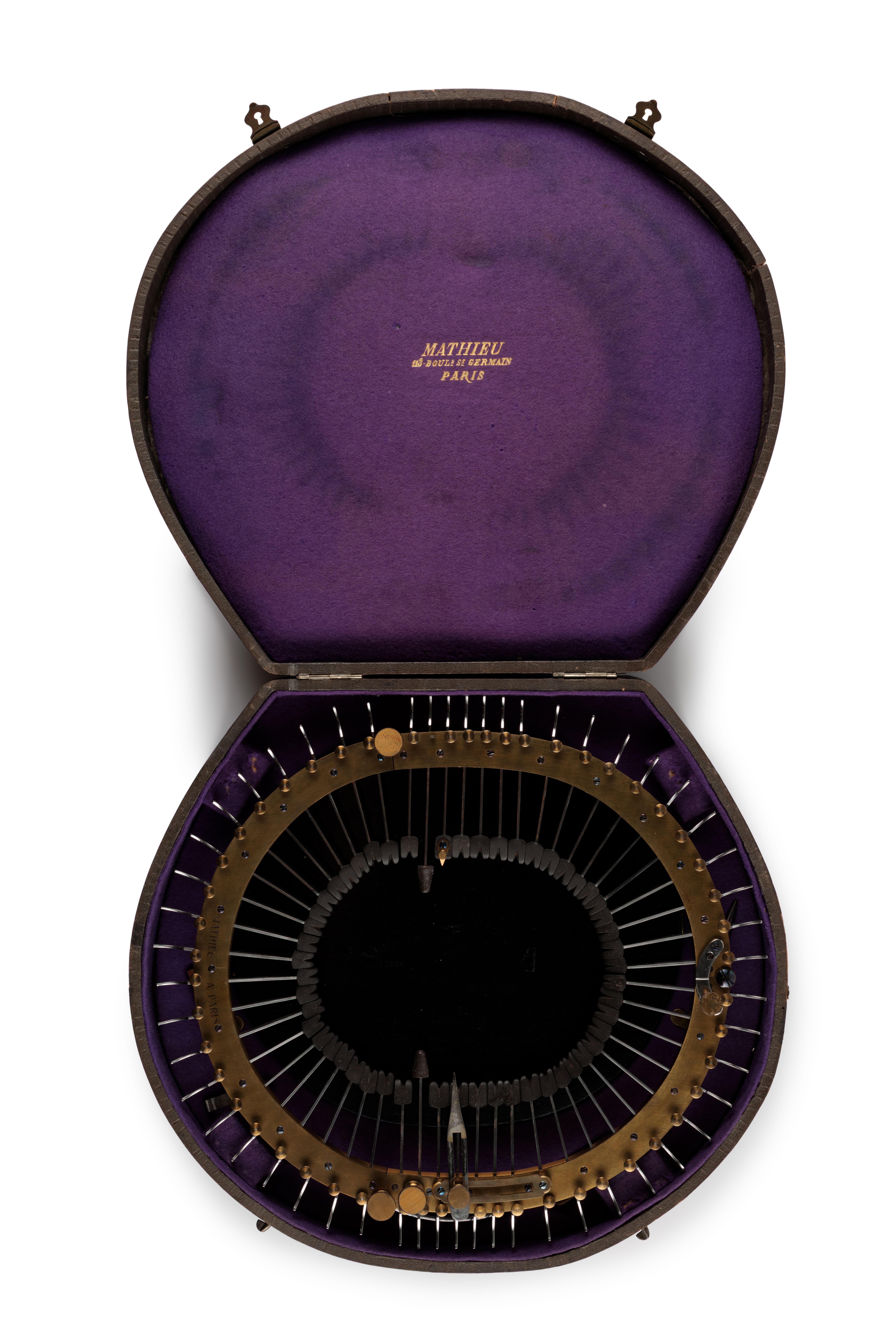 Oval brass frame holding 52 steel spokes (under tension) that are inserted through frame towards centre. The components are held within a wooden box, covered with dark brown leather and lined with purple felt-34cm long. The interior lid is marked in gold writing: Mathieu/113 Boud St Germain/Paris.