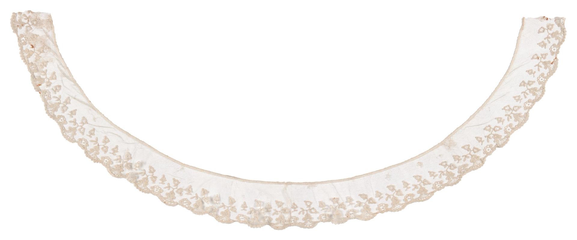 A lace collar, bobbin applique on machine made net with needle lace filling, made of cotton. Horseshoe in shape the collar features a scrolling floral design with a scalloped edge and machine made bobbin engrelure. The collar is made using cloth stitch bobbin lace motifs appliqued to machine made net. The design is embellished with needle lace fillings. Lace collar is made of cotton.