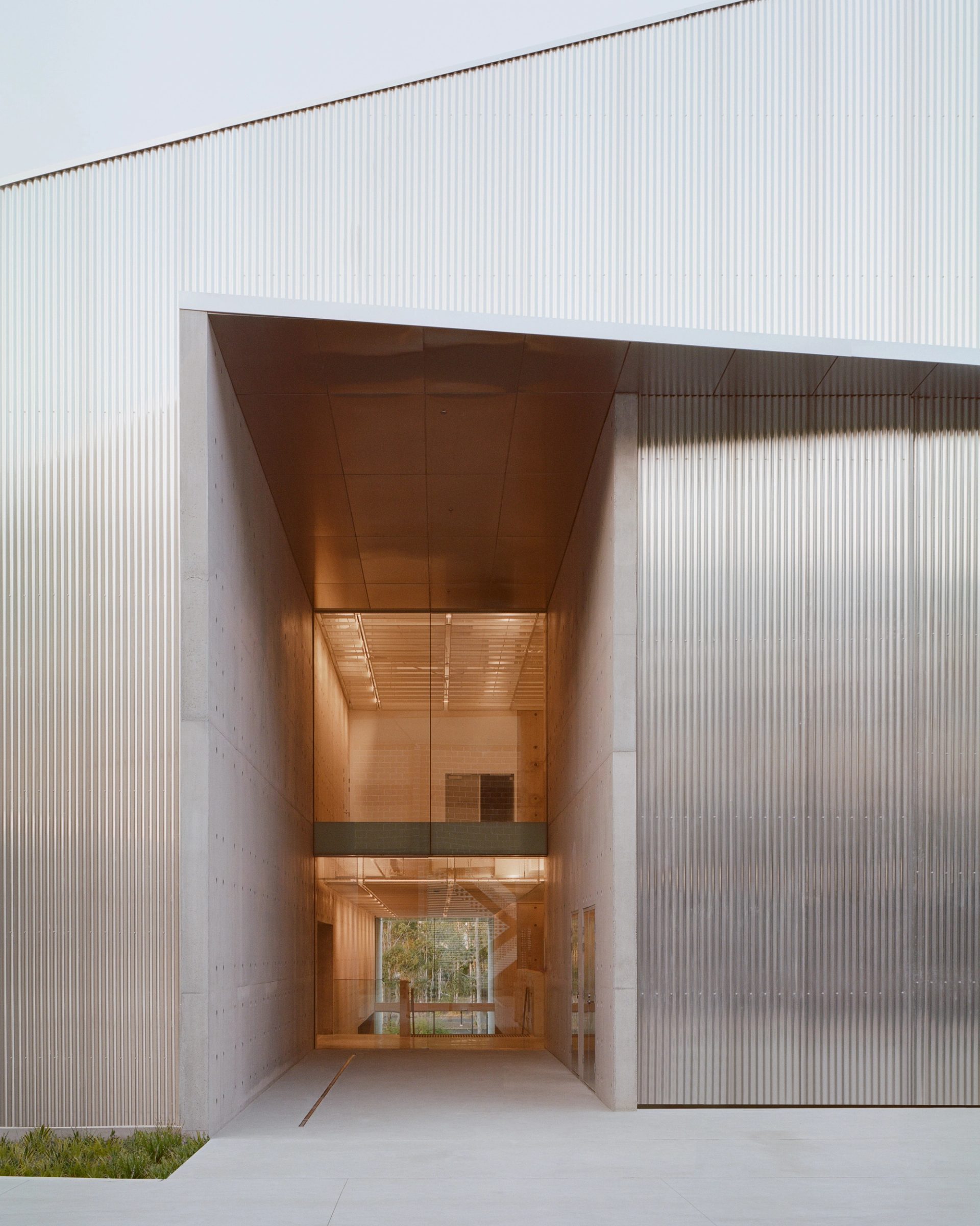 A large entrance way made of concrete, leading to exhibition space.