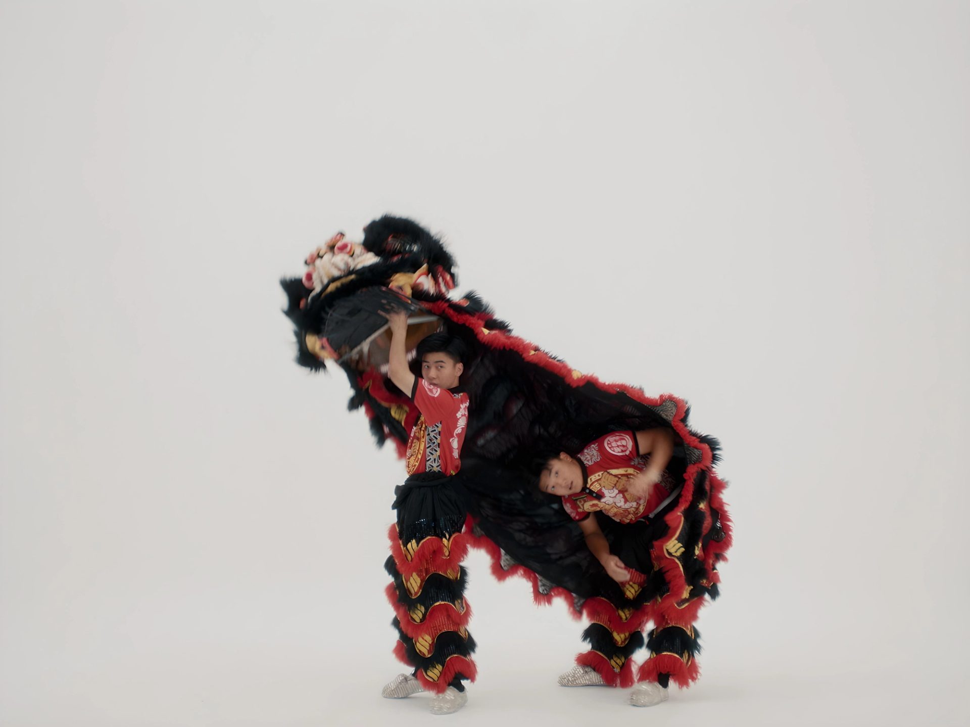 Two men coming out from under a lion costume