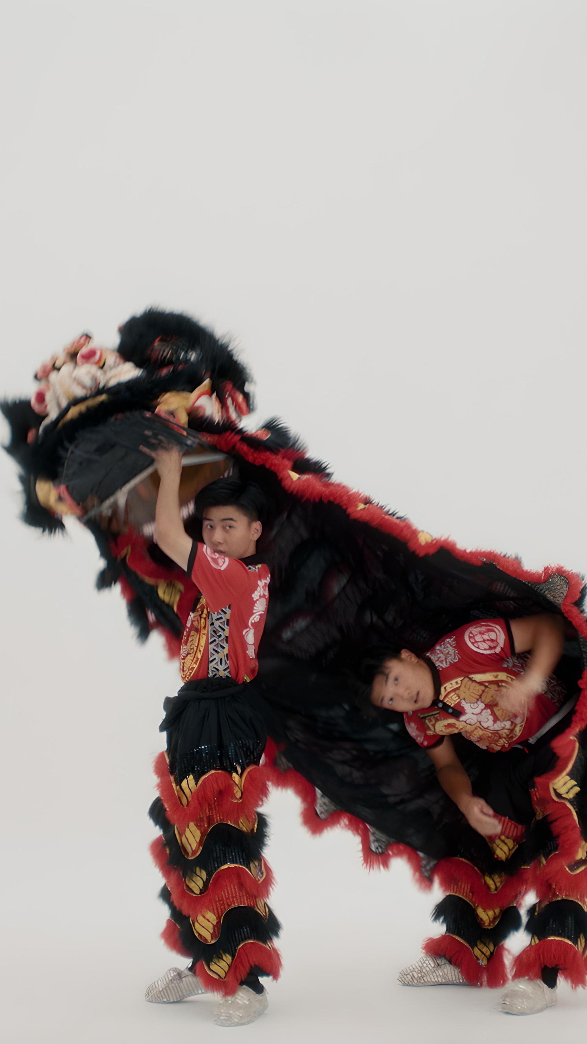 Two men coming out from under a lion costume