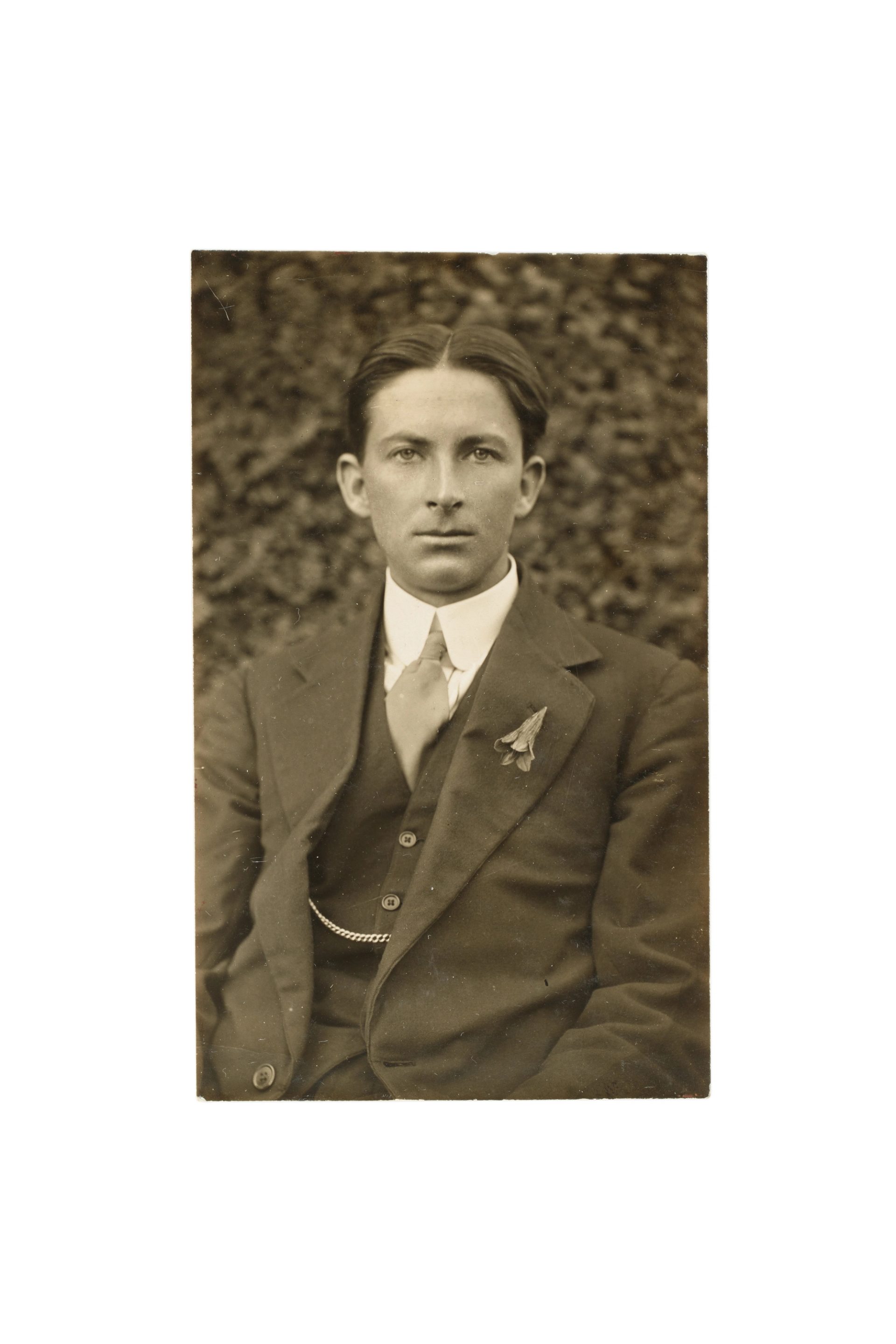 Historic black-and-white photograph of a young person in a three-piece suit, their hair centre-parted and wearing a necktie and pocket handkerchief.