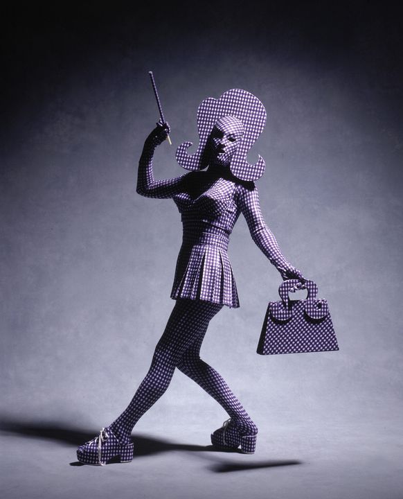 Costume made of blue and white checked lycra gingham and comprising full bodysuit, mask, bra top, mini skirt, clogs, and handbag.