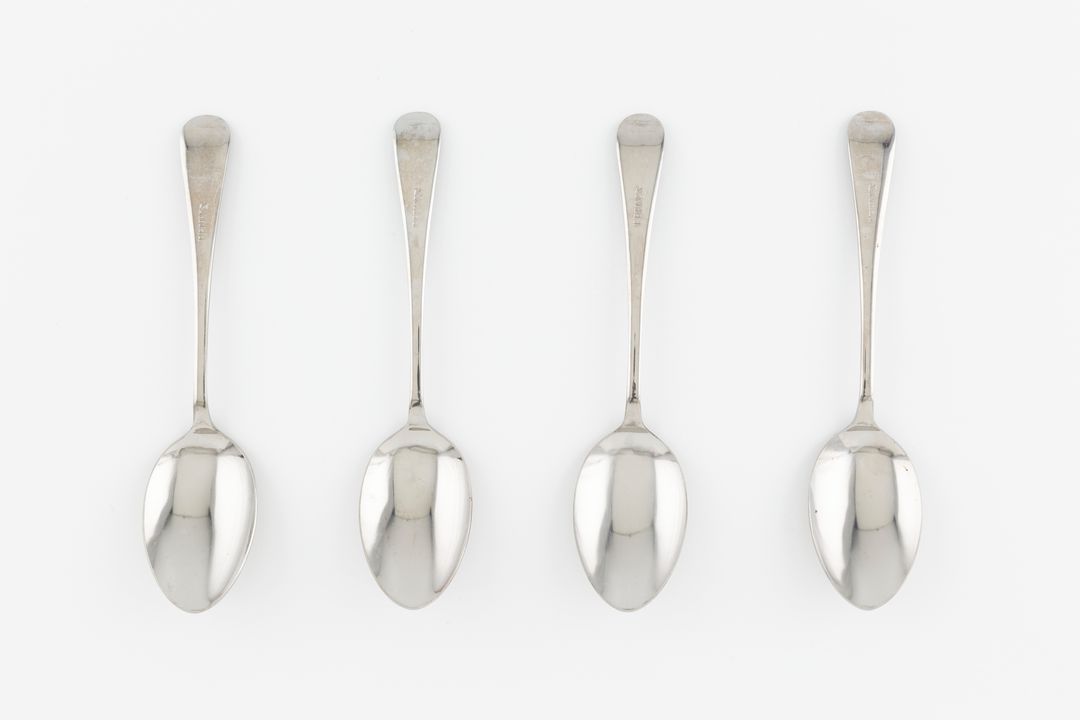 Four matching silver coloured tablespoons.