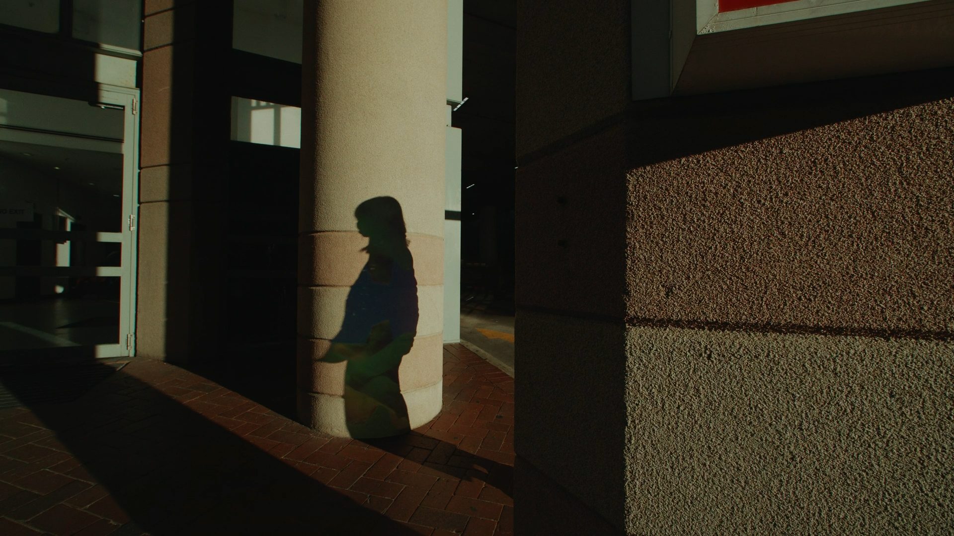 shadow of figure amongst pillars of a building