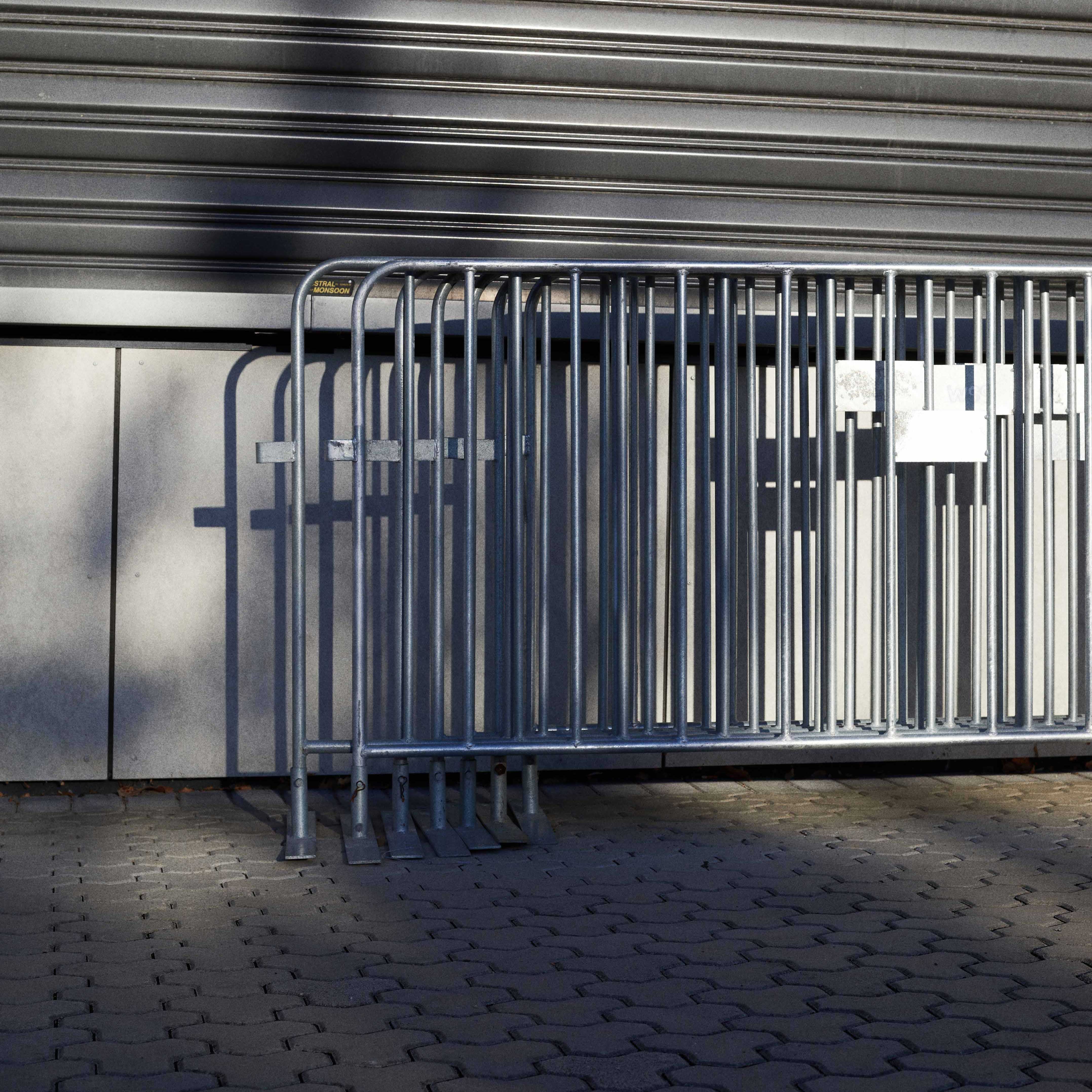 Silver fencing stacked together and leaning on a wall.