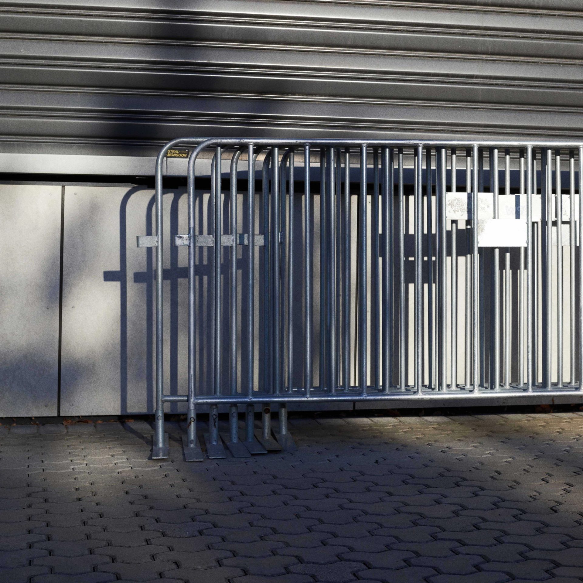Silver fencing stacked together and leaning on a wall.