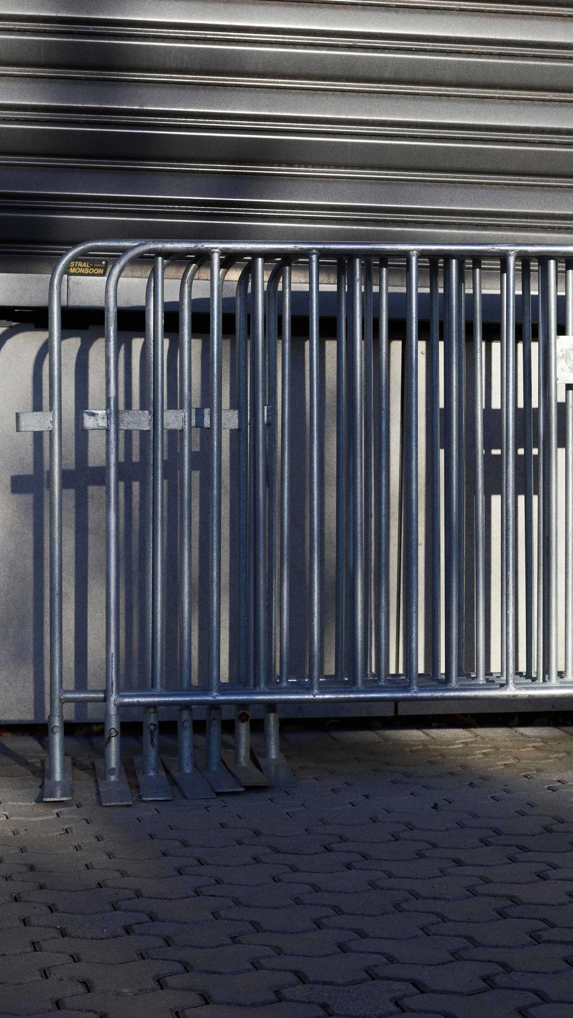 Silver fencing stacked together and leaning on a wall.