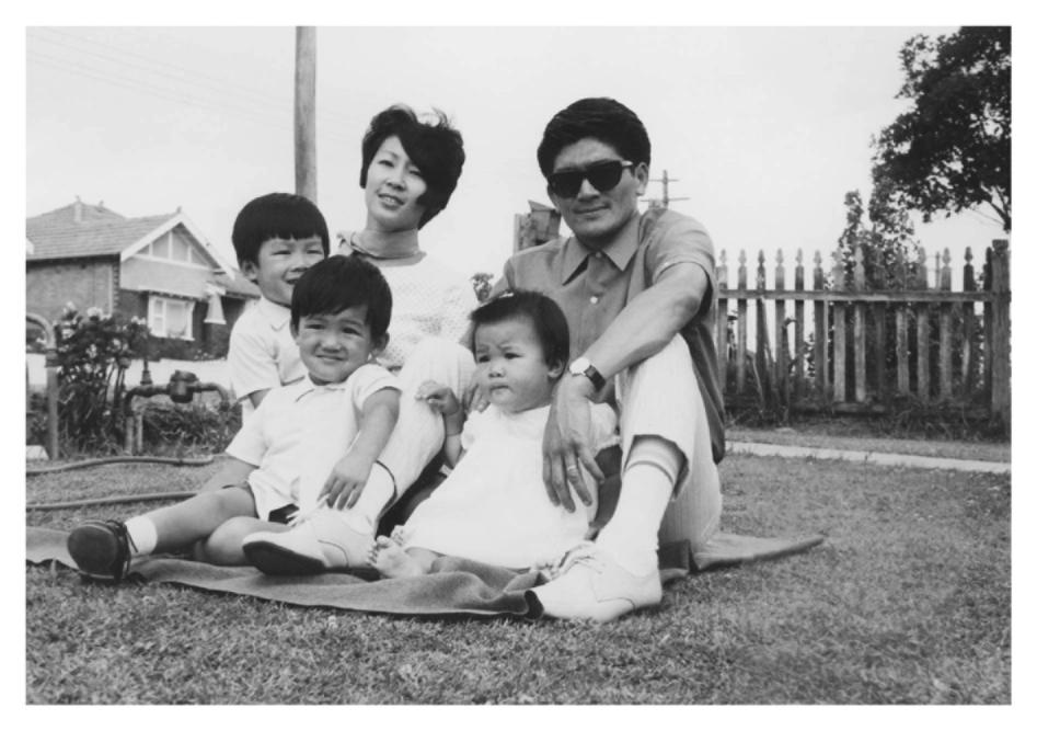 A black-and-white photograph of five members of Kylie Kwong’s family sitting on a blanket in a grassy yard.