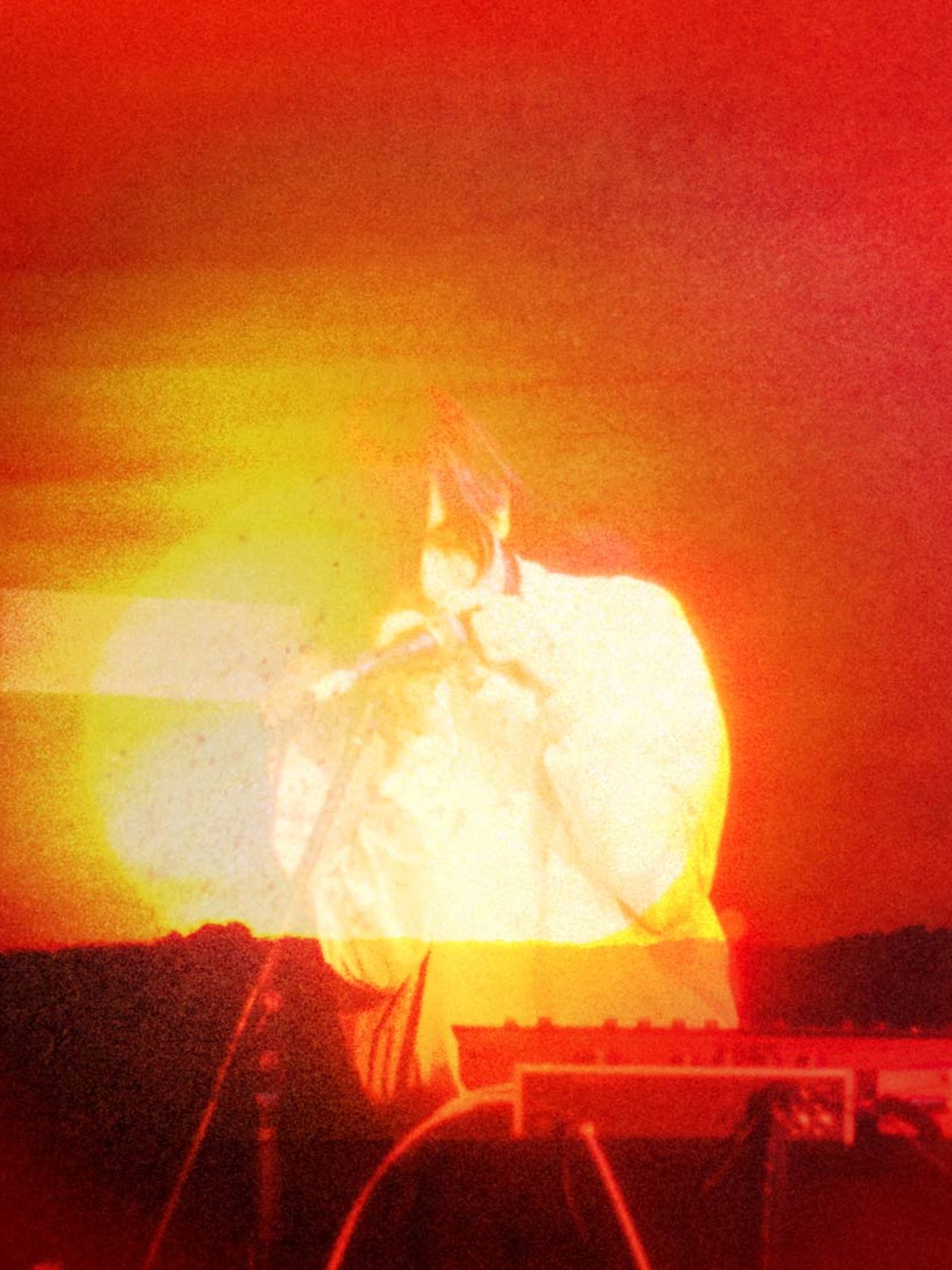 Photo bashed motion image with bright orange sunsets and natural textures over a silhouette of musician e fishpool.