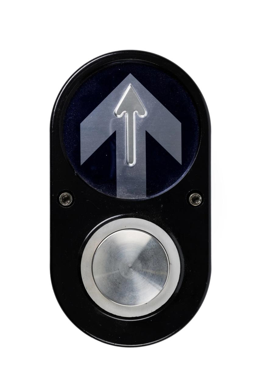 Pedestrian button with upward arrow atop.