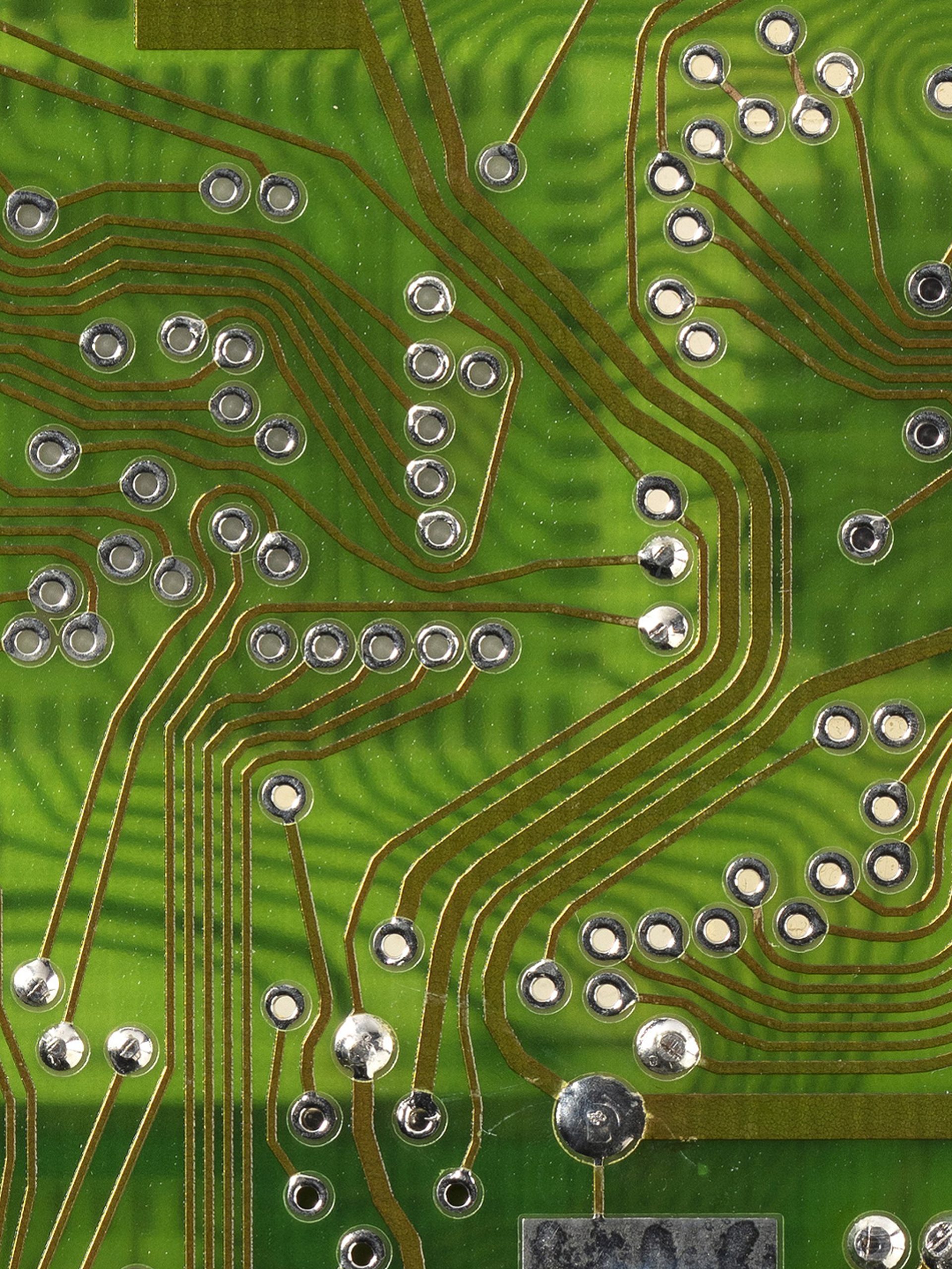 Image of a 4211 cardiac pacemaker with their outing casing removed to reveal the device's internal circuitry which is covered with a partial clear rubber cover. There is one orange plastic internal lining of a pacemaker.