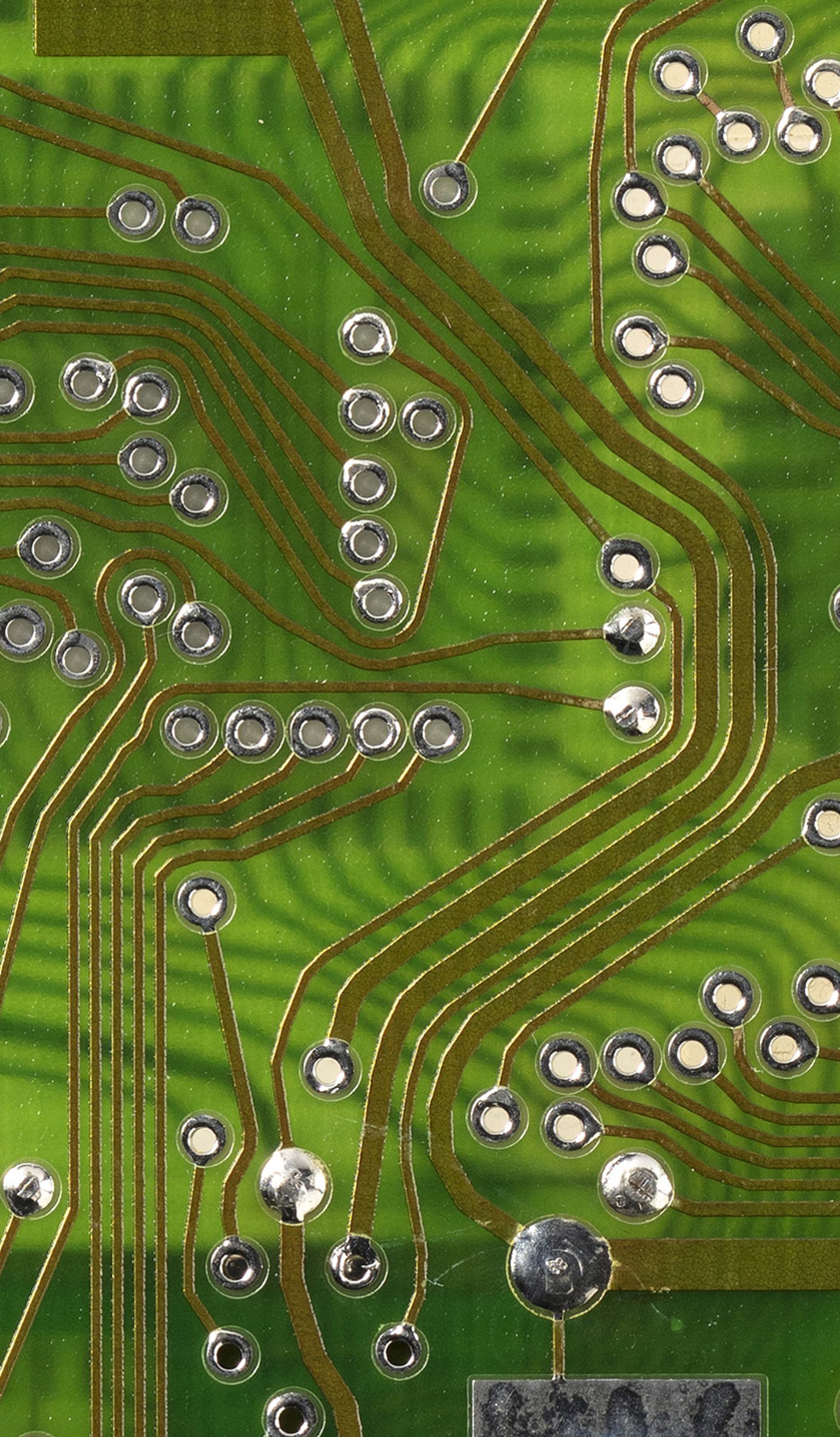 Image of a 4211 cardiac pacemaker with their outing casing removed to reveal the device's internal circuitry which is covered with a partial clear rubber cover. There is one orange plastic internal lining of a pacemaker.