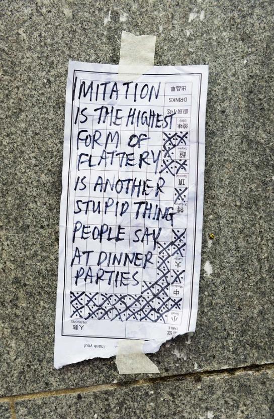 Note reading “IMITATION IS THE HIGHEST FORM OF FLATTERY IS ANOTHER STUPID THING PEOPLE SAY AT DINNER PARTIES”