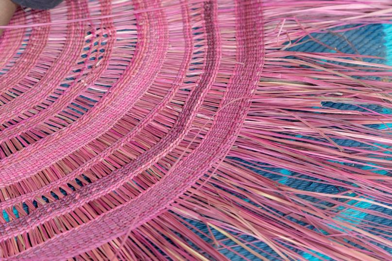 A closeup of a large pink woven mat.