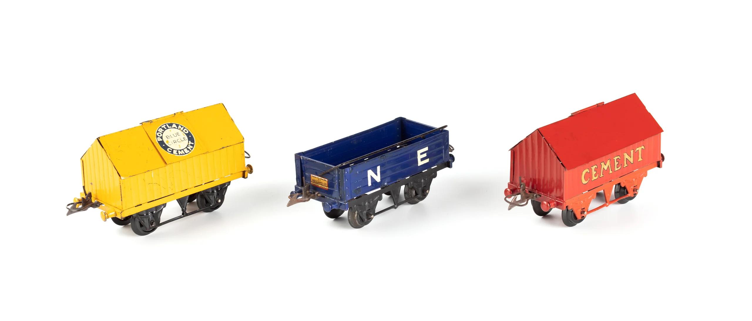 Three miniature toy railway carriages in yellow, blue and red.
