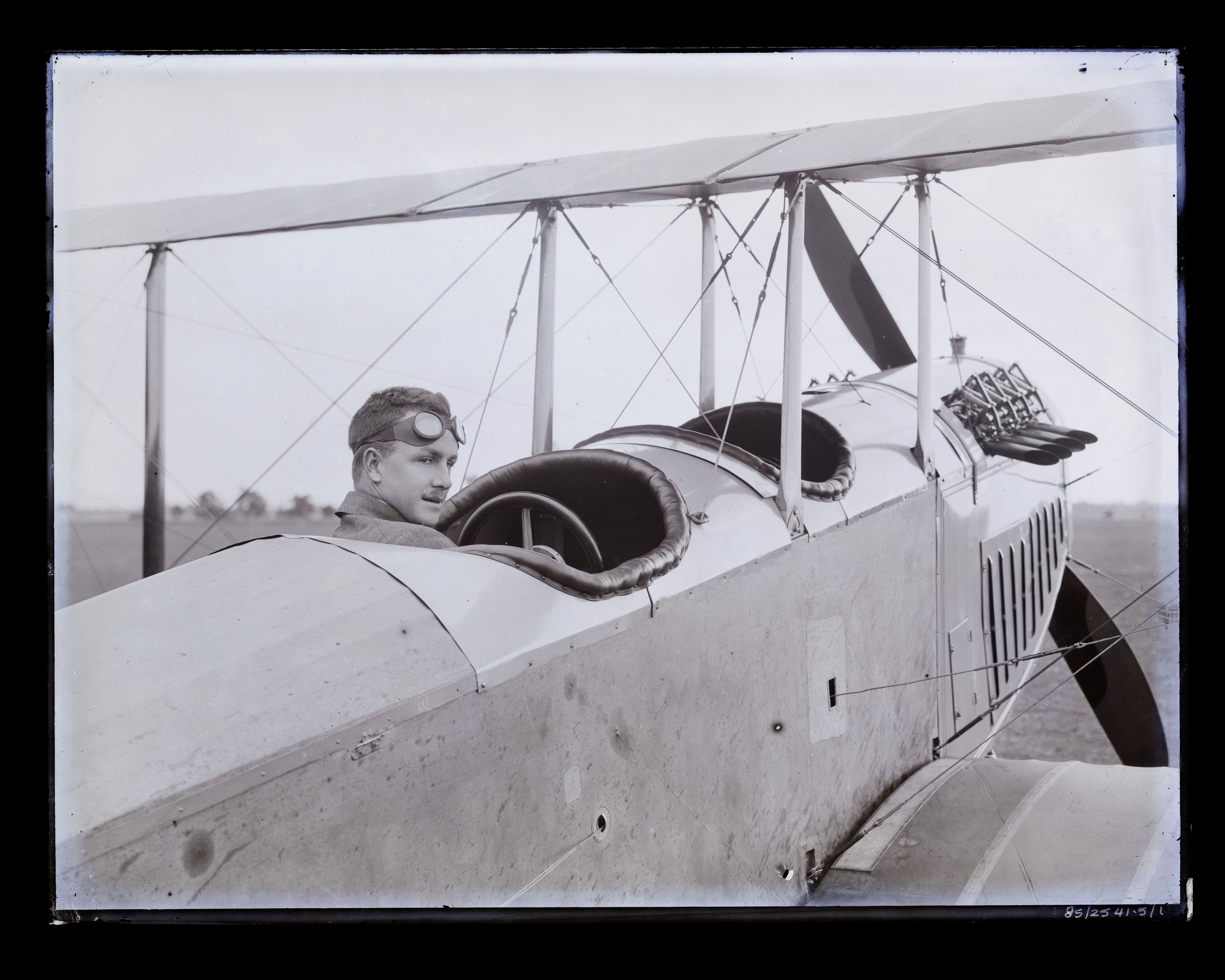 Glass plate negative, image of trainee aviator, probably Cecil Roy Burton looking left, wearing goggles, in on the NSW State Aviation School's Curtiss JN/3-4 aircraft at Richmond.