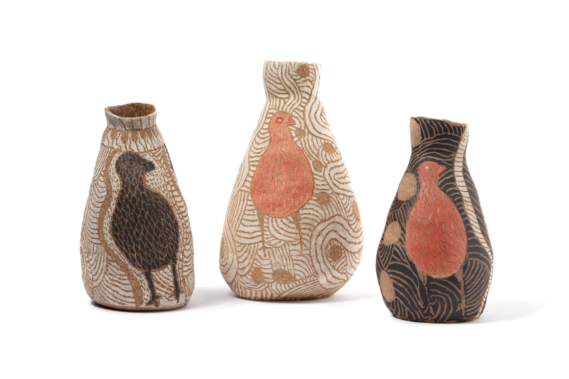 Three small standing stoneware vase that rests on a wide rounded base that continues at a slant to the neck and widens to create an opening.