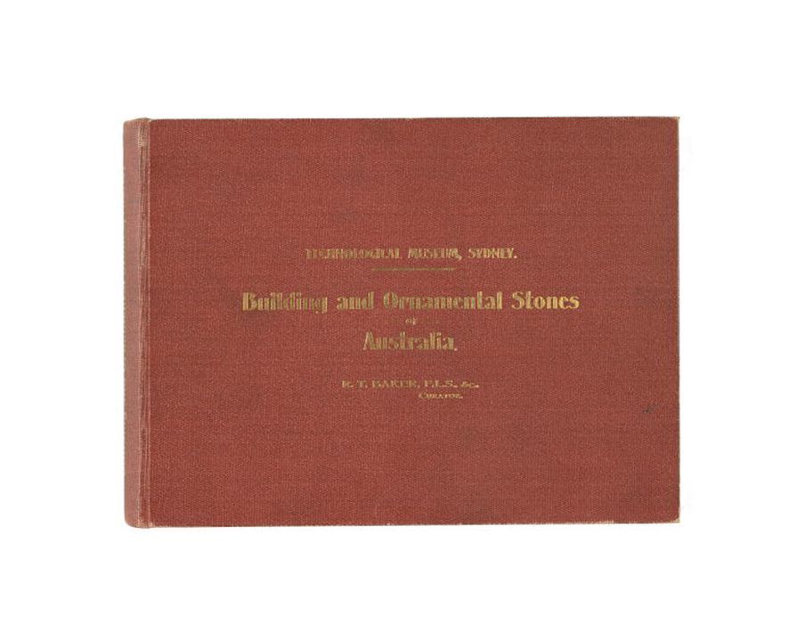 Red hardcover book, Building and Ornamental Stones of Australia (1915) by Richard Thomas Baker, photographed against a white background