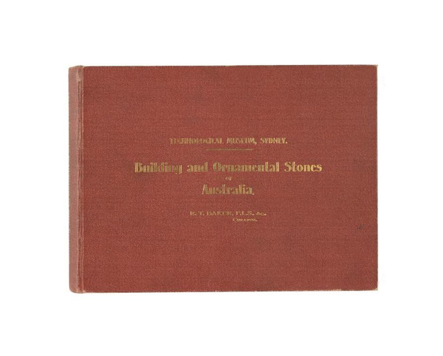 Red hardcover book, Building and Ornamental Stones of Australia (1915) by Richard Thomas Baker, photographed against a white background