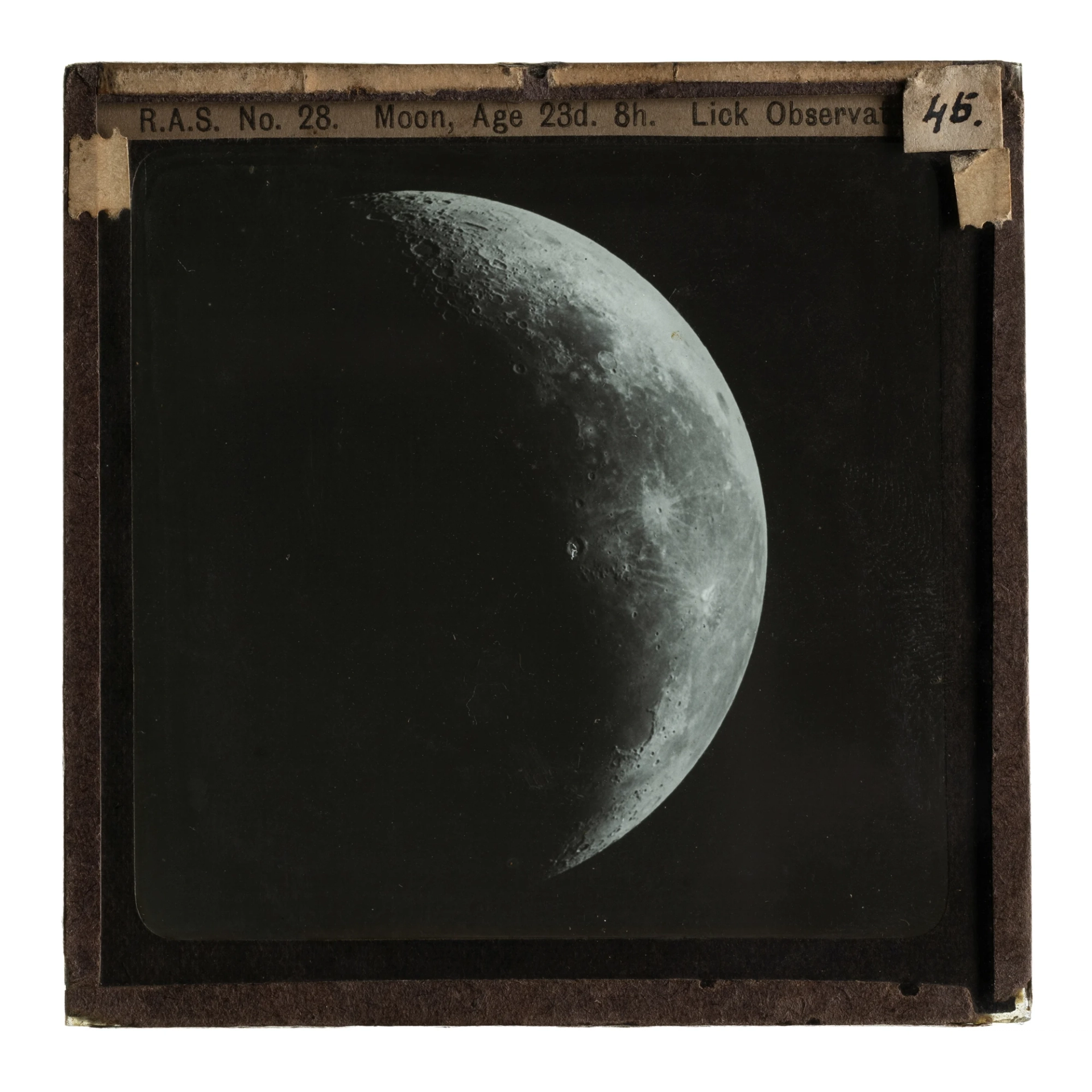 A glass plate slide showing an image of a crescent Moon.