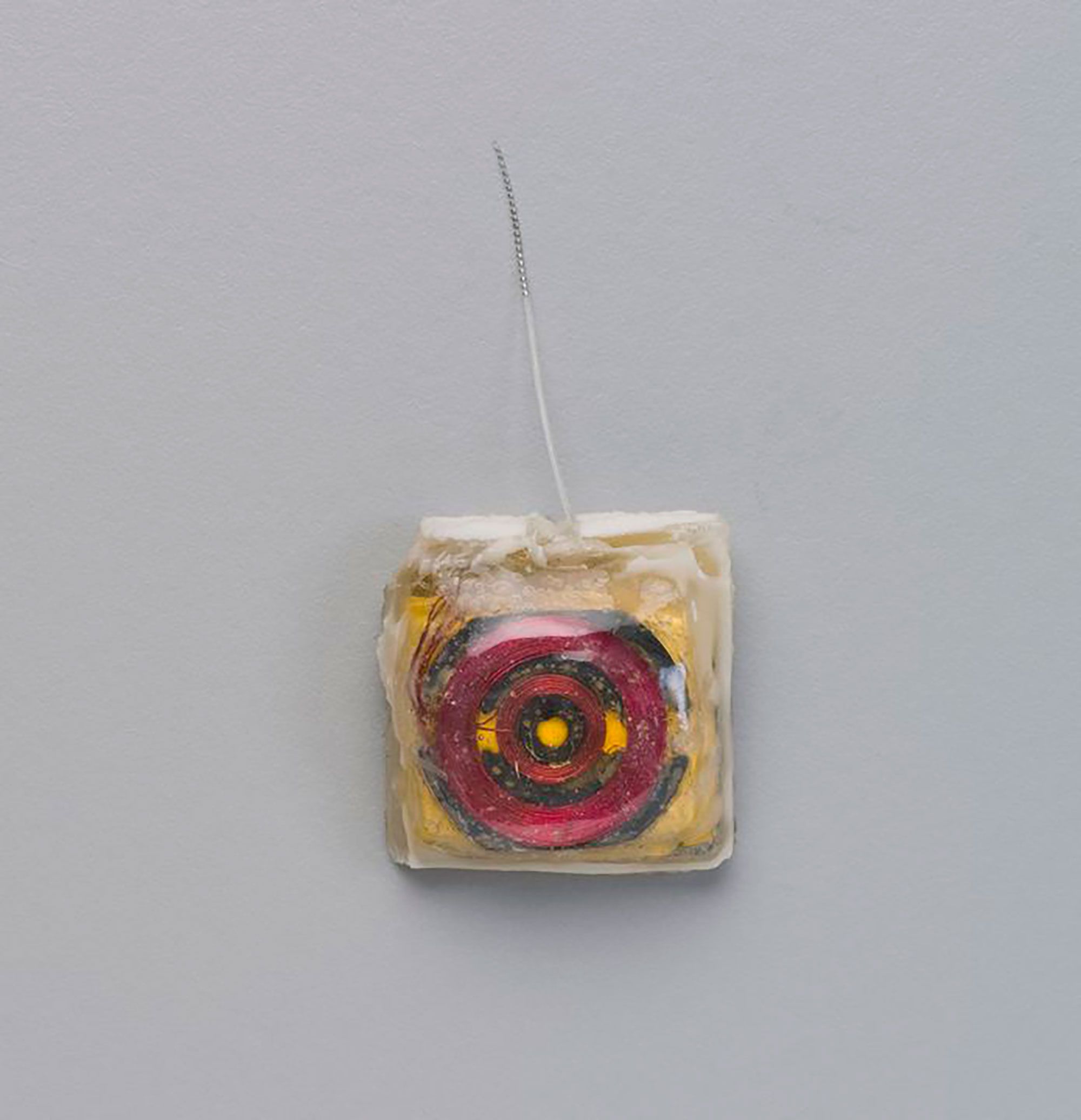 Red and gold cochlear implant prototype photographed on grey background