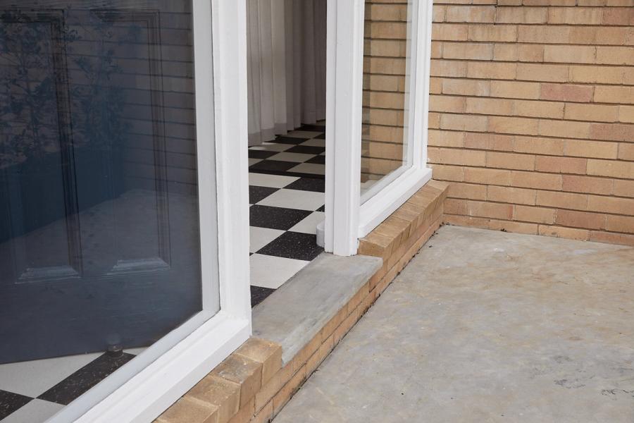 Entrance to house, with chequered tiles, concrete and brick