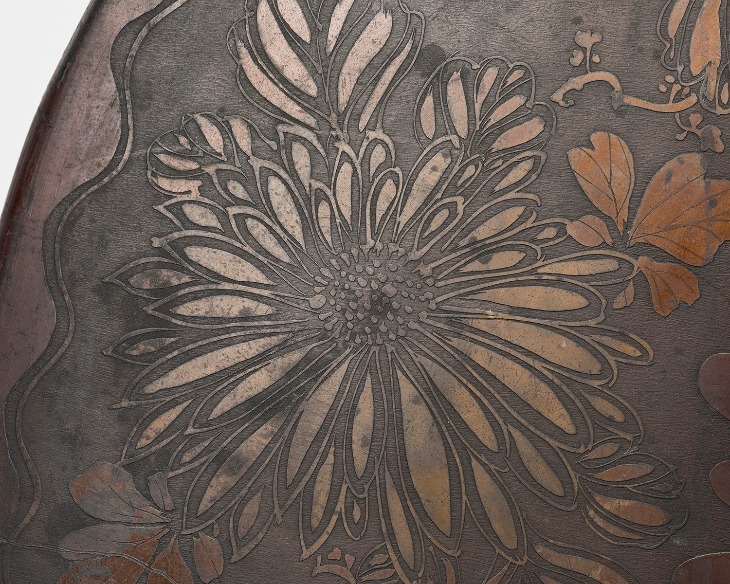 Close up image of the decorative surface of the gong depicting a flower.