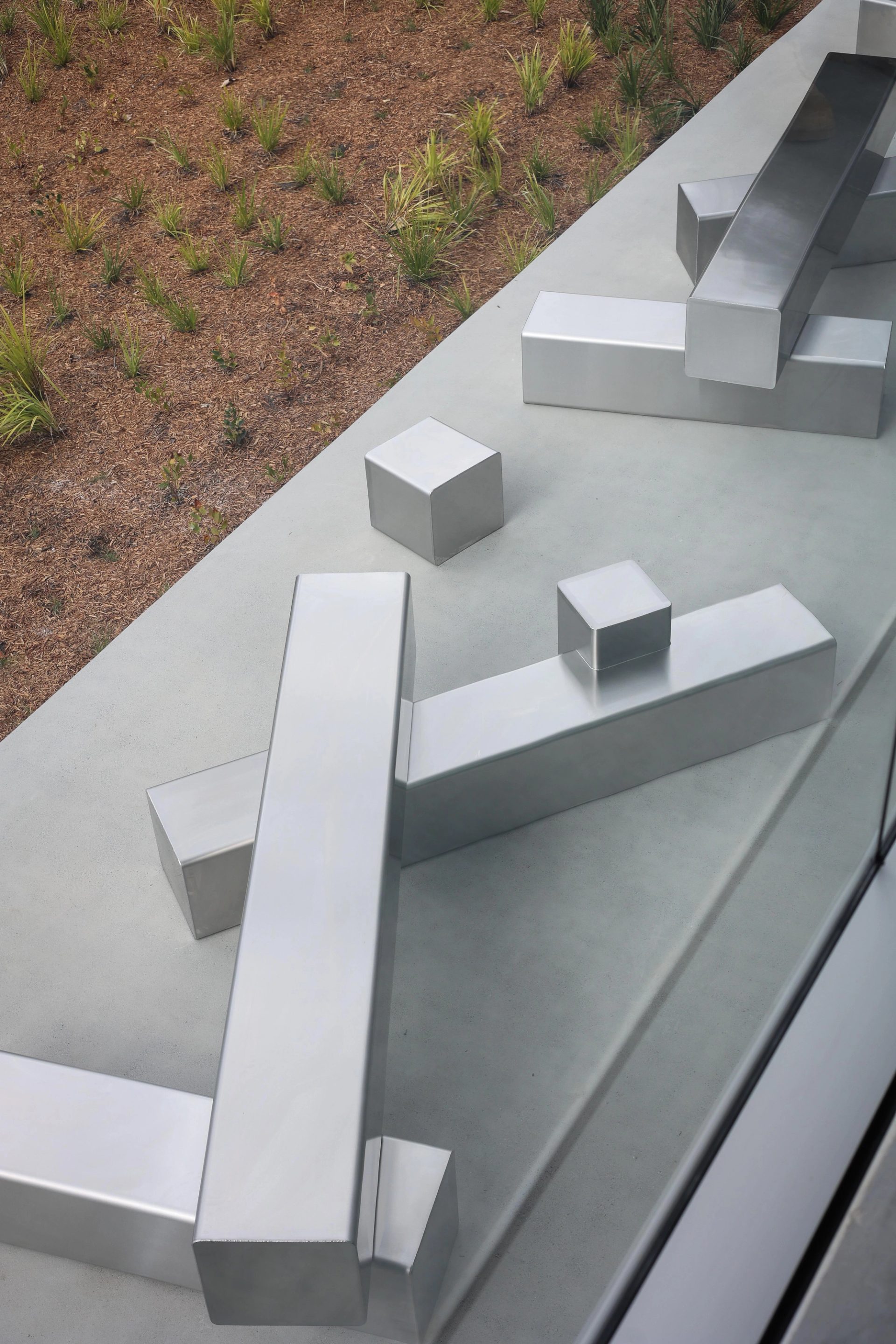 Steel blocks stacked on an outdoor concrete slab.