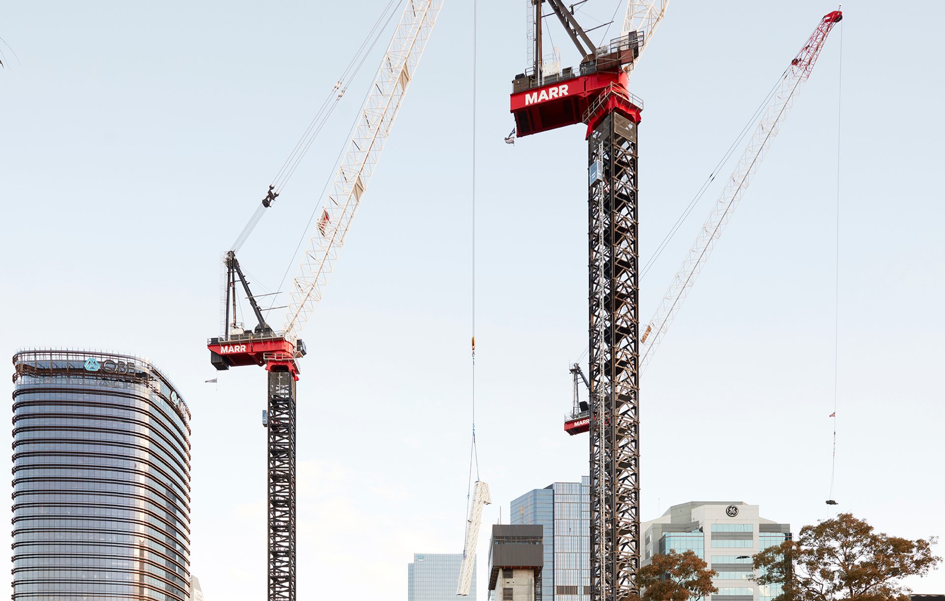 Two tall industrial cranes towering over a construction site.