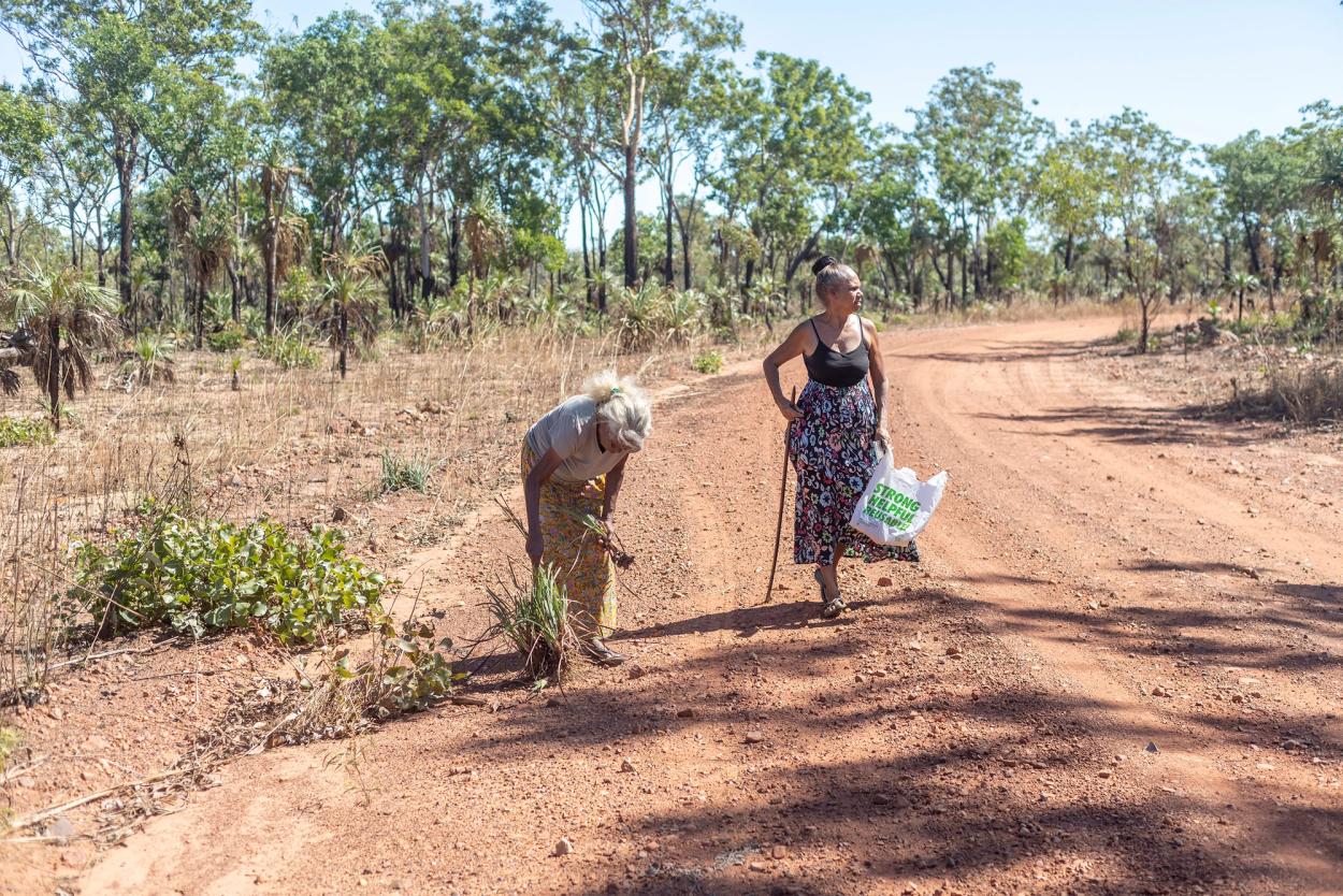 Two women on a red dirt road.
