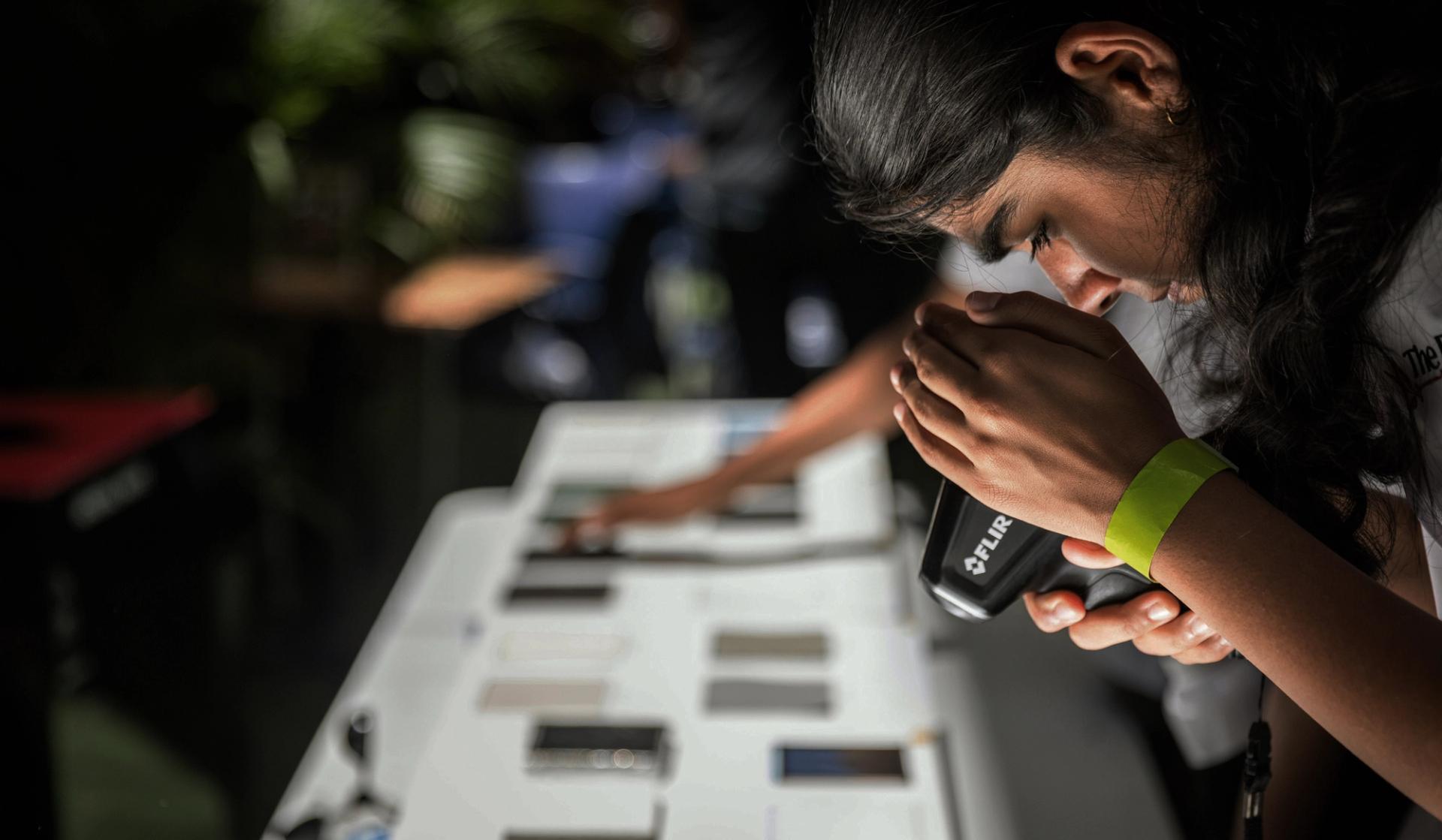 Student looking into a tool.