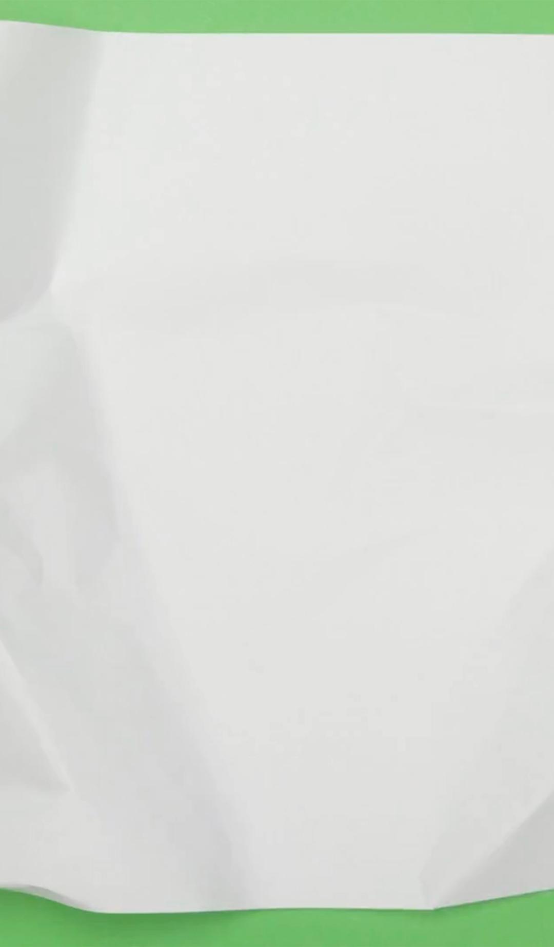 Animated footage of a sheet of paper being scrunched down to a ball, against a bright green background.
