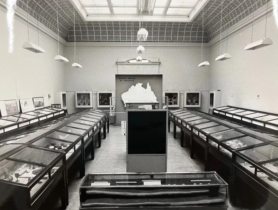 Black and white photograph of museum display with a large map of Australia at the centre