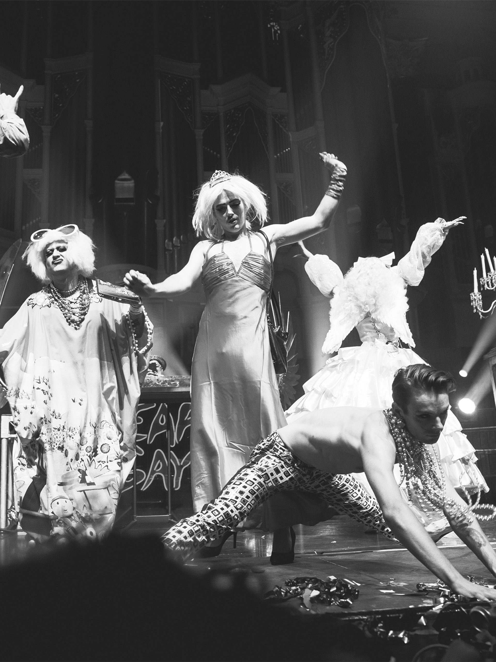 Black and white photo of five performers dancing on stage at a Heaps Gay party.