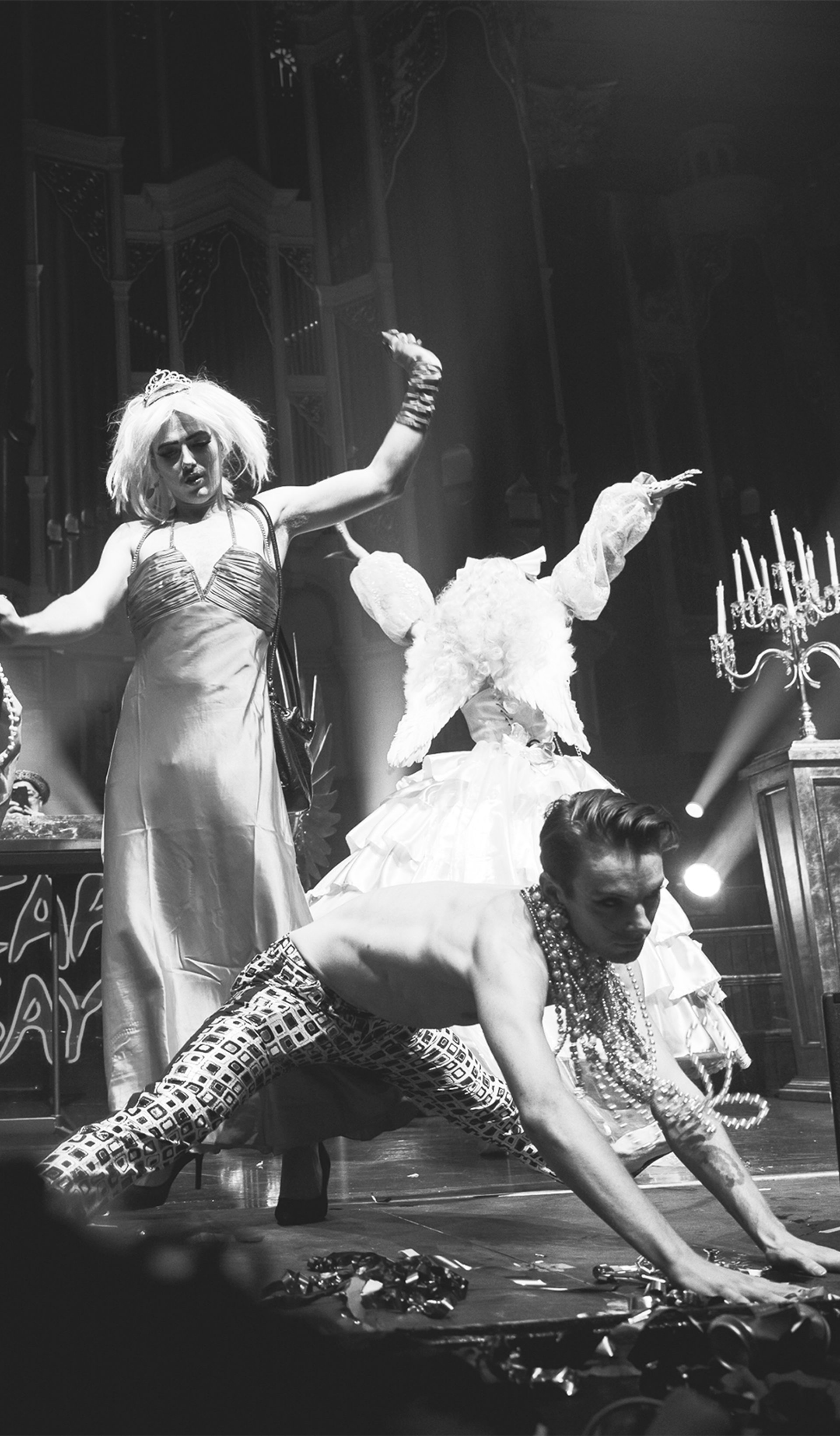 Black and white photo of five performers dancing on stage at a Heaps Gay party.