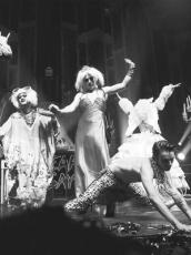 Black and white photo of five performers dancing on stage at a Heaps Gay party.